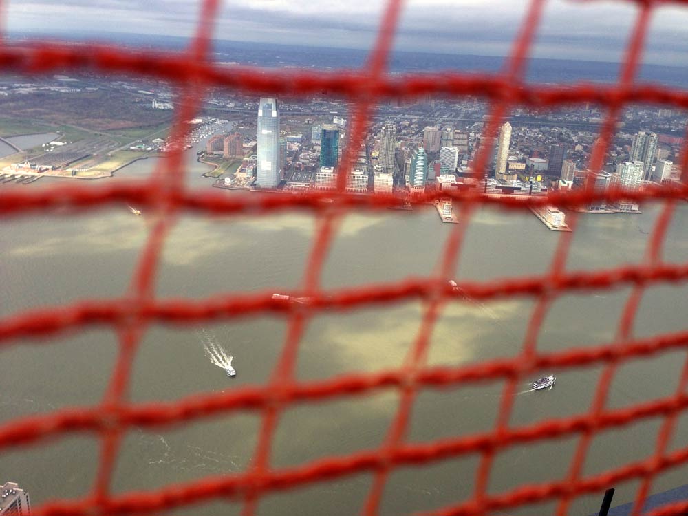 A vertigo-inducing shot of the views from WTC as seen through mesh netting.