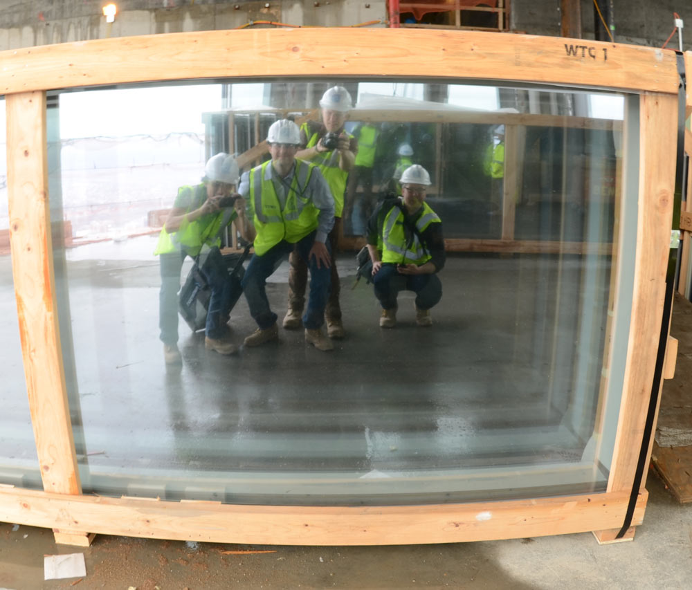 Members of the Floored team reflected in an uninstalled piece of glass.